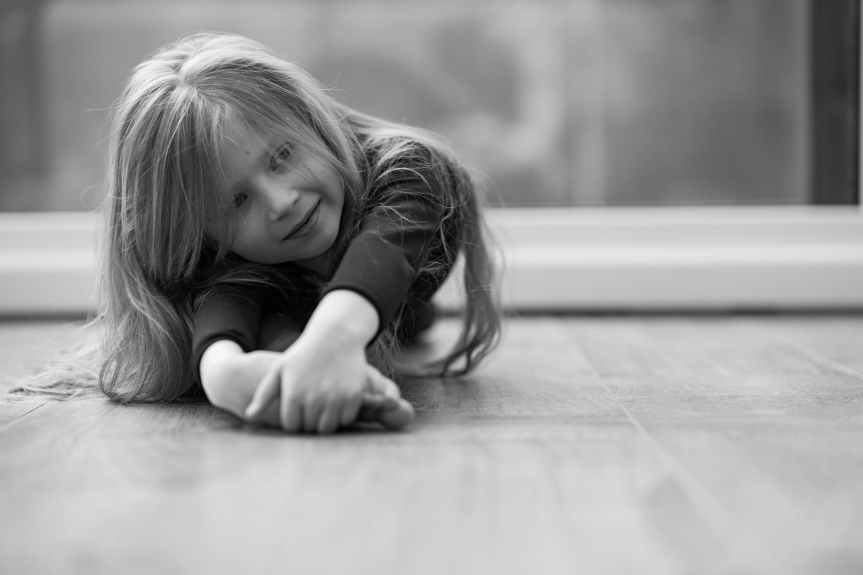 grayscale photo of girl lying on floor